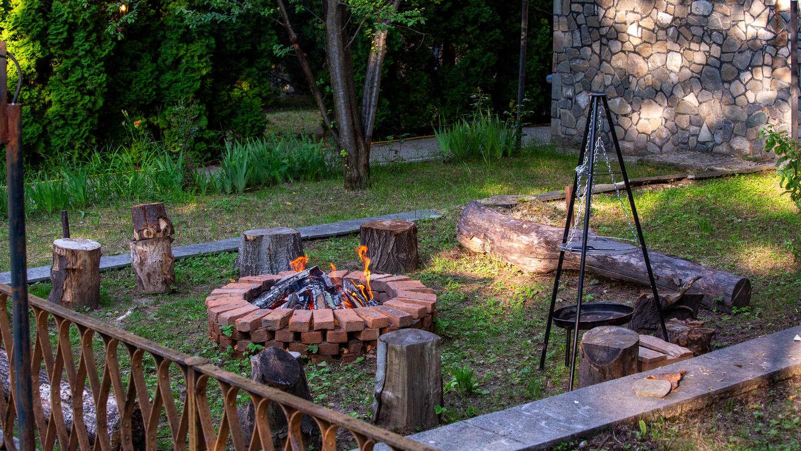 Fire-pit cu focul aprins și grătar exterior lângă piscina Casei Rodica Breaza
